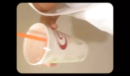אלינה מראה כוס עם סרטי פורנו לצפיה ישירה אצבעות.
